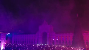 Havai fişek gösterisi geceleri Ticaret Meydanı Lisbon 'u aydınlatıyor. Portekiz, Lizbon 'da yeni yıl boyunca düzenlenen inanılmaz havai fişek gösterisini bir grup turist izliyor.