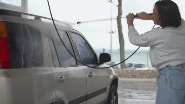 셀프서비스 세차에 펌프를 우연한 여성은 샴푸와 분무기로 씻습니다 — 비디오