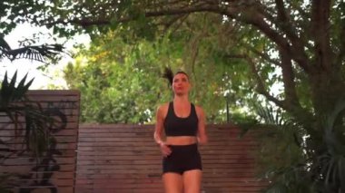 Spor giyim bölümünde koşan atletik bir kadın. Açık havada günlük idman sırasında koşan kadın koşucu. Kadın fitness koşucusu spor sağlık konsepti.