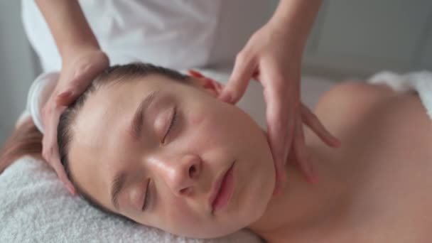 Entspannte Frau Erhält Eine Verjüngende Hautpflege Kosmetikschrank Vom Masseur Der Stock-Filmmaterial