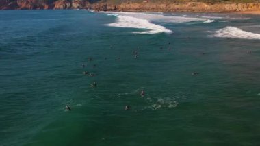 Hava manzaralı sörfçüler Portekiz kıyısındaki bir sörf noktasında kuyruk oluşturmayı bekliyorlar. Atlantik Okyanusu 'nda sörf, aşırı yaşam tarzı, tatil ve seyahat. Üstgeçit Guincho sahilini vurdu.