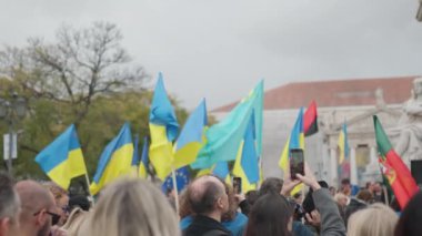Ukrayna bayrağı taşıyan kadın ve erkek, Portekiz 'de Ukrayna' daki savaş ve Rus işgalini protesto ediyor. Avrupa kentinden Ukrayna 'ya destek