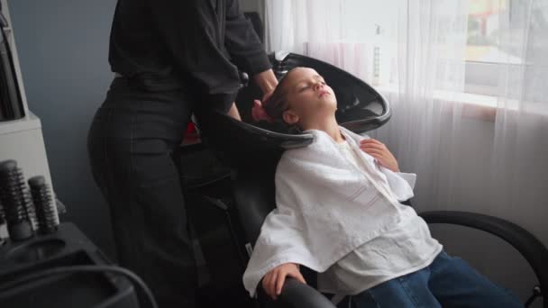 Fille Détendue Ayant Ses Cheveux Lavés Par Coiffeur Dans Salon Vidéo De Stock Libre De Droits