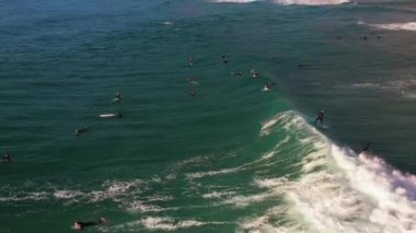 İHA hava gözlem grubu sörfçüleri Portekiz kıyılarındaki bir sörf noktasında dalgaların hizalanmasını bekliyorlar. Atlantik Okyanusu 'nda sörf, aşırı yaşam tarzı, tatil ve seyahat. Üstgeçit Guincho plajını vurdu Portekiz