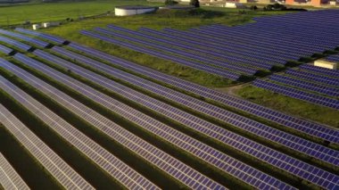 Çiftlik arazileri üzerindeki güneş panelleri evler ve şirketler için yenilenebilir enerji kaynağı üretiyor. Güneş ışığından gelen alternatif enerji kaynağı. Hava aracı görüntüsü.