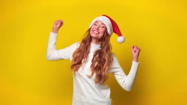 Cheerful Woman Santa Hat Dancing Bright Yellow Background Young Caucasian — стокове відео