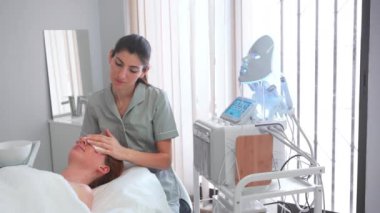 Kadın güzellik uzmanı, estetik tedavi, rahatlama, gençleşme, renk terapisi, ışık terapisi, cilt bakımı için LED maske kullanıyor..