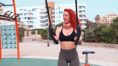 Spor salonunda spor aletleri tutan sportif bir kadın. Aktif giyimli genç bir kadın gündüz vakti parkta spor yapıyor.. 