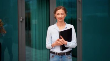 Ofis binasının dışında yürürken elinde klasör tutan kendine güvenen bir iş kadını. Zeki, genç bayan profesyonel kameralara bakarken el sıkışma teklif ediyor.. 