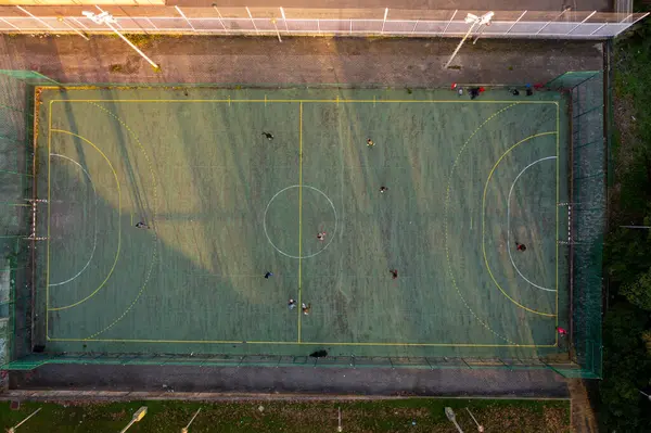 stock image Aerial drone top view of mini football soccer field with artificial plastic cover with playing people. Public sport ground in city at sunny summer day drone view