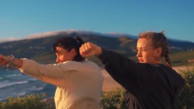 Güneşli bir günde Windy Beach 'te boks yapmaya odaklanmış kadın boksörler. Güçlü genç kadın dövüşçüler doğada egzersiz yapıyorlar.. 