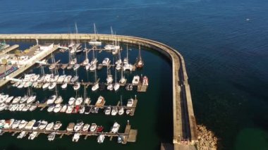 Portekiz 'deki Cascais marinasındaki rıhtımlarda demirli yelkenlileri yakalayan hava aracı. Güneşli bir günde şehrin limanındaki teknelerin yukarıdan çekimleri. 