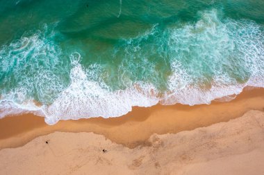 Havadan kumsal manzarası, yaz tatili şablonu afişi. Dalgalar inanılmaz mavi okyanus gölü, deniz kıyısı, kıyı şeridi ile sörf yapar. Kumsal, panorama. Kumsalın panoramik manzarası.
