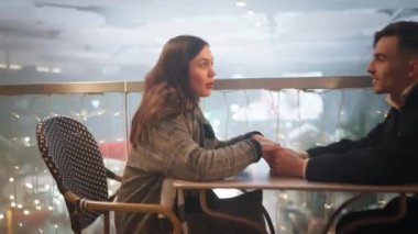 Noel gecesi teras restoranında el ele tutuşan romantik bir çift. Mutlu kadın festival sezonunda erkeklerle kaliteli zaman geçiriyor.. 