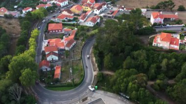 Sintra, Portekiz 'in yerleşim alanındaki dolambaçlı yolu yakalayan İHA' nın hava görüntüleri. Huzurlu mahallede yol esiyor. Arabalar geçiyor.