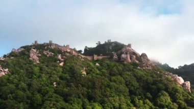 Sintra, Portekiz 'deki Fas Kalesi' nin havadan görünüşü. Kale yemyeşil ağaçlar ve yoğun bitki örtüsüyle çevrili bir dağda bulunuyor.