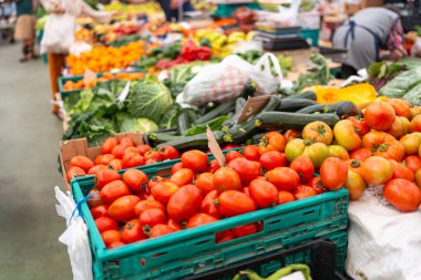 Gündüz vakti Avrupa açık hava pazarında taze sebzeler sergileniyor. Süpermarkette kabaklı ve lahanalı domateslerin yüksek açılı çekimi.. 