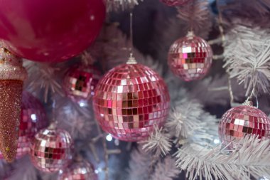 Evdeki Noel ağacında asılı parlak pembe mücevherlerin yakın çekimi. Xmas arifesinde tam çerçeve dekorasyon. 