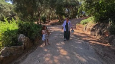 Aile küçük kızı ve büyükannesi, yemyeşil sakin bir çevreyle çevrili huzurlu doğa yolu boyunca rahatça gezinerek kırsal alanda birlikte geçirdikleri kaliteli zamanı artırıyor..