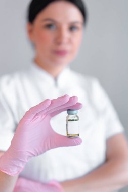 Kadın dermatolog klinikte enjeksiyon için ilaç şişesi tutuyor. Genç kozmetoloji terapisti güzellik salonunda.. 