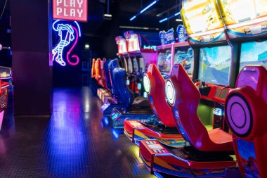 Oyun Merkezi: Aydınlatılmış oyun sahasında boş oyun sandalyeleri. Bir alışveriş merkezinde çocuklar oyun oynuyor.. 