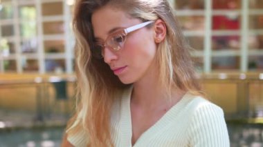 Gülümseyen genç kadın gündüzleri kaldırımdaki kafede otururken roman okumaktan hoşlanır. Kadın kendini kitaplara kaptırdığı için rahatlamış ve halinden memnun. 