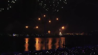 Lizbon, Portekiz Noel kutlaması için gece gökyüzünü havai fişeklerle aydınlatıyor. Canlı renkler suyu yansıtır, neşeli bir atmosfer yaratır.