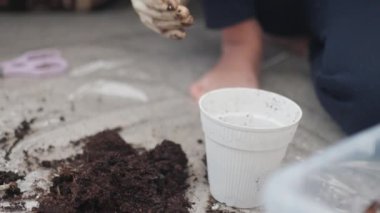 İnsan içeride bitki ekmeye hazırlanıyor, toprağı karıştırıyor ve saksı ekiyor. Küçük alanlar ve yeni başlayanlar için uygun olan bahçıvanlık teknikleri üzerinde yoğunlaşıldı.