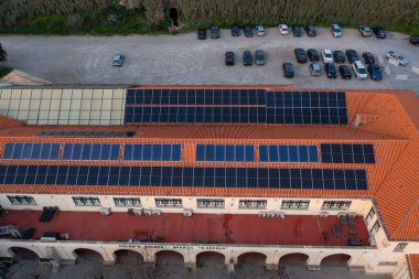 Çatıdaki fotovoltaik paneller park alanının hava manzarasının yanında. Binanın çatısında yenilenebilir güneş enerjisi 