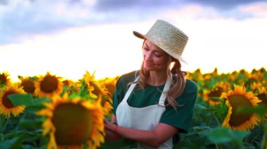 Dişi çiftçi güneş batarken canlı bir tarlada ayçiçekleriyle ilgilenirken nazikçe gülümser ve sıcak bir parıltı saçar. Bu huzurlu an, doğanın ve yalnızlığın güzelliğini yakalar..