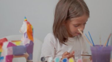 Evde oturmuş sanat projeleri hazırlayan ve yaratıcılığını ifade eden genç bir kız.
