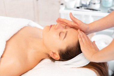 Anonim kozmetik uzmanları güzellik salonunda kadınlara masaj yapıyor. Rahatlamış bayan müşteri güzellik uzmanları tarafından şımartılıyor.. 