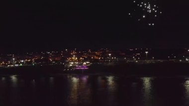 Portekiz, Estoril 'de suyun üzerinde patlayan muhteşem yeni yıl havai fişeklerinin insansız hava aracı görüntüleri. Canlı renkler suyu yansıtıyor ve bu ikonik şehirde göz kamaştırıcı bir gece gösterisi yaratıyor.