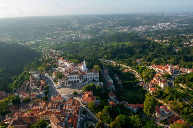 Hava aracı görüntüsü Sintra Ulusal Sarayı 'nın uçsuz bucaksız manzarasını gösteriyor. Sahne, bu tarihi yerin hem mimari ihtişamını hem de doğal güzelliğini yakalıyor. 