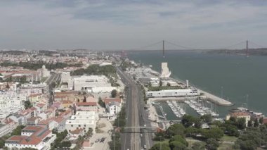 25 Nisan Köprüsü 'nün arka planda Tagus Nehri' ni kapladığı Lizbon şehrinin hava aracı görüntüsü gökyüzünün altındaki canlı şehir manzarasını gözler önüne seriyor.