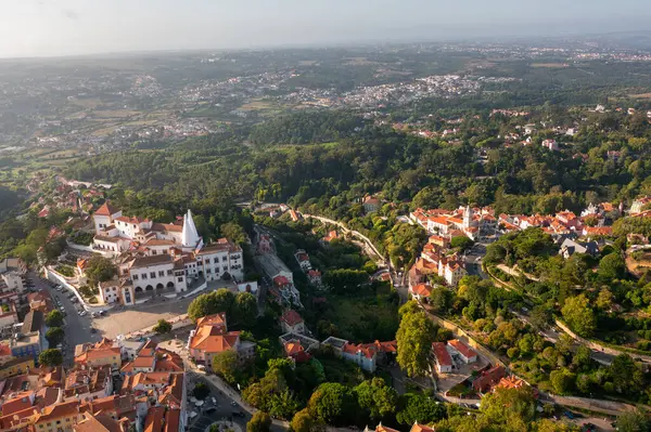 Sintra Ulusal Sarayı 'nın tepedeki hava manzarası güneşli bir günde gökyüzüne karşı belirgin mimarisini sergiliyor.