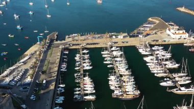 Portekiz 'deki Cascais marinasına demirlemiş yelkenlilerin insansız hava aracı görüntüsü sakin sularla huzurlu limanı ve pitoresk kıyı şehrine kenetlenmiş tekneleri gösteriyor.