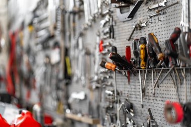 Atölyede tahta üzerinde düzenlenmiş çeşitli el aletleri. Tornavidalar, anahtarlar ve kerpeten düzgün yerleştirilmiş kolay erişim için, garajda işlevsel bir çalışma alanı oluşturur