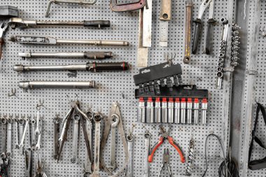 Mekanik onarım ve bakım işleri için düzenli çalışma alanı oluşturan atölye tahtasına düzenli olarak yerleştirilmiş çeşitli el aletleri ve soket anahtarlarıName