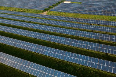 Sahada sıralı panelleri olan güneş çiftliği, kirliliğin azaltılması ve sürdürülebilir bir geleceğin desteklenmesinde yenilenebilir enerjilerin rolünü vurguluyor