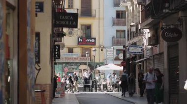 Valencia, İspanya 3 Mayıs 2025 Valencia, İspanya 'da dar sokaklar boyunca yürüyen insanlar, renkli binalar, tabelalar ve kafeler, tarihi şehir merkezinde canlı şehir atmosferi
