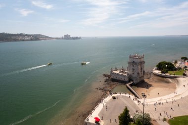 Tagus Nehri 'ndeki Belem Kulesi' nin hava aracı görüntüsü suda uyanmalar yaratıyor, Lisbons 'un manzaralı deniz manzarası ve tarihi mimarisini vurguluyor.