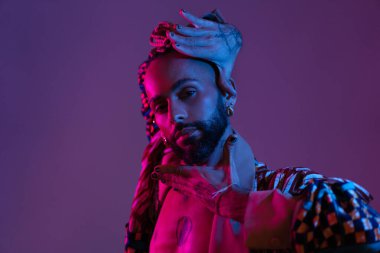 Retro dalga ya da sentetik dalga portresi ciddi Afro-Amerikan dansçı erkek stüdyo çekimi tarzında. Yüksek modacı erkek model renkli parlak neon ışıklarda dans ediyor..