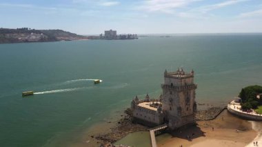 Belem Kulesi 'nin Lizbon' daki Tagus Nehri 'nin yakınındaki teknelerle çekilen insansız hava aracı görüntüleri bölgedeki ikonik anıt ve su aktivitelerini vurguluyor.