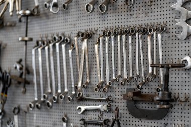 Atölyede tahta üzerinde düzenlenmiş çeşitli el aletleri. Tornavidalar, anahtarlar ve kerpeten düzgün yerleştirilmiş kolay erişim için, garajda işlevsel bir çalışma alanı oluşturur