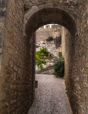 Tarihi bir kalenin duvarlarında küçük taşlarla döşenmiş dar bir tünel gibi..
