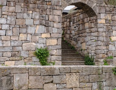 Tarihi bir kalenin duvarlarında küçük taşlarla döşenmiş dar bir tünel gibi..