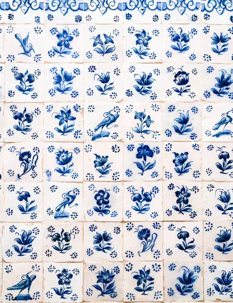 Background of various blue porcelain tiles on the wall of a Portuguese city building.