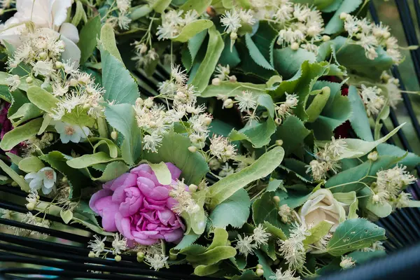 stock image A wreath of linden flowers with a purple flower at the summer solstice; selective focus.