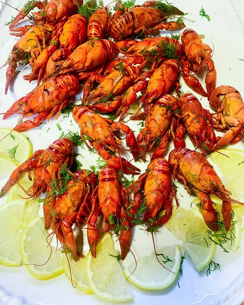 Bir sürü kırmızı haşlanmış kerevit masada limon dilimleri ile birlikte..